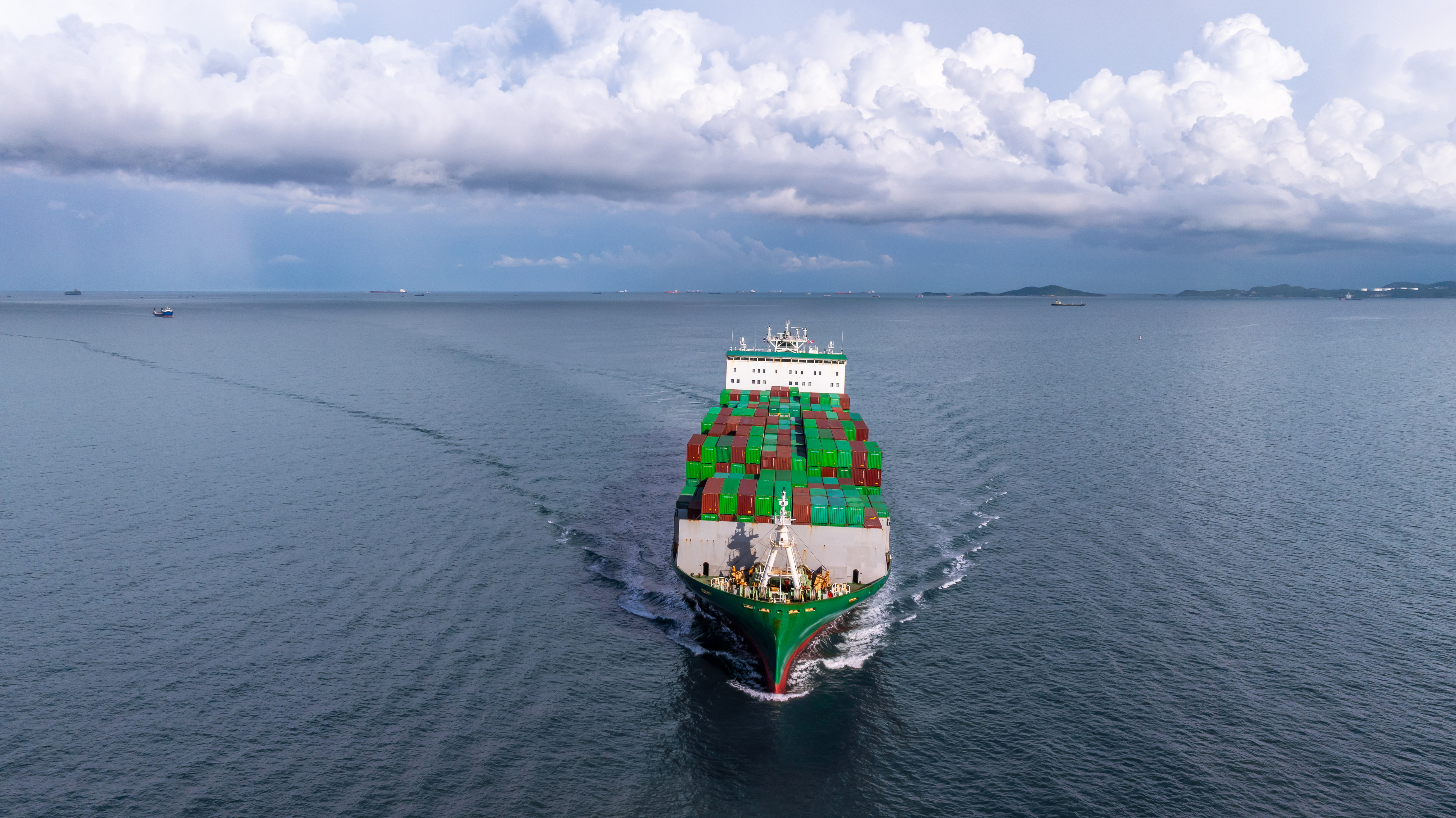 Container ship with colorful cargo containers at sea - aerial view